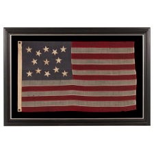 13 STAR ANTIQUE AMERICAN FLAG, WITH A MEDALLION CONFIGURATION OF HAND-SEWN STARS ON A DUSTY BLUE CANTON, A SMALL-SCALE EXAMPLE OF THE LATE 19TH CENTURY
