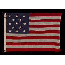 13 STAR ANTIQUE AMERICAN FLAG WITH A 3-2-3-2-3 CONFIGURATION OF STARS ON AN ATTRACTIVE, INDIGO BLUE CANTON; A SMALL-SCALE EXAMPLE OF THE 1895-1926 ERA, INSCRIBED WITH THE SURNAME “SPENGE,” LIKELY PRODUCED BY A MAKER WITH LINKS TO THE U.S. ARMY’S 19th CORPS