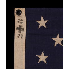 13 STAR ANTIQUE AMERICAN FLAG WITH A 3-2-3-2-3 CONFIGURATION OF STARS ON AN ATTRACTIVE, INDIGO BLUE CANTON; A SMALL-SCALE EXAMPLE OF THE 1895-1926 ERA, INSCRIBED WITH THE SURNAME “SPENGE,” LIKELY PRODUCED BY A MAKER WITH LINKS TO THE U.S. ARMY’S 19th CORPS