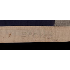 13 STAR ANTIQUE AMERICAN FLAG WITH A 3-2-3-2-3 CONFIGURATION OF STARS ON AN ATTRACTIVE, INDIGO BLUE CANTON; A SMALL-SCALE EXAMPLE OF THE 1895-1926 ERA, INSCRIBED WITH THE SURNAME “SPENGE,” LIKELY PRODUCED BY A MAKER WITH LINKS TO THE U.S. ARMY’S 19th CORPS