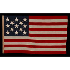 13 STAR ANTIQUE AMERICAN FLAG WITH A 3-2-3-2-3 PATTERN OF ESPECIALLY LARGE STARS; A U.S. NAVY SMALL BOAT ENSIGN, ALMOST CERTAINLY MADE AT MARE ISLAND, CALIFORNIA, circa 1906-1912, LARGER THAN THE SPECIFIED DIMENSIONS & UNCHARACTERISTICALLY UNSIGNED; EXTREMELY RARE