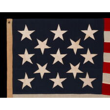 13 STAR ANTIQUE AMERICAN FLAG WITH A 3-2-3-2-3 PATTERN OF ESPECIALLY LARGE STARS; A U.S. NAVY SMALL BOAT ENSIGN, ALMOST CERTAINLY MADE AT MARE ISLAND, CALIFORNIA, circa 1906-1912, LARGER THAN THE SPECIFIED DIMENSIONS & UNCHARACTERISTICALLY UNSIGNED; EXTREMELY RARE