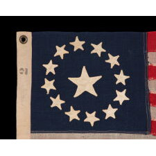 13 STAR ANTIQUE AMERICAN FLAG, IN A TINY SCALE AMONG PIECED-AND-SEWN EXAMPLES OF THE 19TH CENTURY, WITH HAND-SEWN STARS ARRANGED IN A CIRCULAR VERSION OF WHAT IS KNOWN AS THE 3RD MARYLAND PATTERN; FEATURES AN ESPECIALLY LARGE CENTER STAR, MADE circa 1885-1895