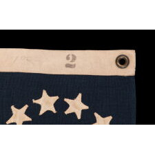 13 STAR ANTIQUE AMERICAN FLAG, IN A TINY SCALE AMONG PIECED-AND-SEWN EXAMPLES OF THE 19TH CENTURY, WITH HAND-SEWN STARS ARRANGED IN A CIRCULAR VERSION OF WHAT IS KNOWN AS THE 3RD MARYLAND PATTERN; FEATURES AN ESPECIALLY LARGE CENTER STAR, MADE circa 1885-1895