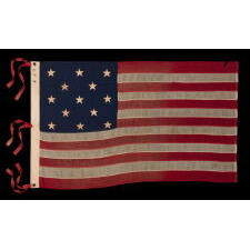 13 STAR ANTIQUE AMERICAN FLAG WITH A 3-2-3-2-3 CONFIGURATION AND AN INK-STAMPED MARK OF THE NEW ENGLAND DECORATING COMPANY OF MASSACHUSETTS, WITH HAND-SEWN, TWILL TAPE TIES, MADE IN THE LAST DECADE OF THE 19TH CENTURY, circa 1892-1899