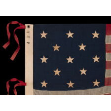 13 STAR ANTIQUE AMERICAN FLAG WITH A 3-2-3-2-3 CONFIGURATION AND AN INK-STAMPED MARK OF THE NEW ENGLAND DECORATING COMPANY OF MASSACHUSETTS, WITH HAND-SEWN, TWILL TAPE TIES, MADE IN THE LAST DECADE OF THE 19TH CENTURY, circa 1892-1899