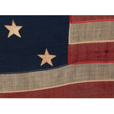 13 STAR ANTIQUE AMERICAN FLAG WITH A 3-2-3-2-3 CONFIGURATION AND AN INK-STAMPED MARK OF THE NEW ENGLAND DECORATING COMPANY OF MASSACHUSETTS, WITH HAND-SEWN, TWILL TAPE TIES, MADE IN THE LAST DECADE OF THE 19TH CENTURY, circa 1892-1899