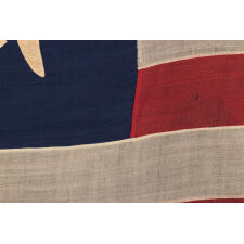 13 STAR ANTIQUE AMERICAN FLAG WITH A BROAD, ARCHED FORMATION OF HAND-SEWN, SINGLE-APPLIQUÉD STARS, ARCH ABOVE A BEAUTIFULLY HAND-SEWN FEDERAL EAGLE, ATTRIBUTED TO FLAG-MAKER SARAH McFADDEN – “NEW YORK’S BETSY ROSS” – AT 198 HUDSON STREET IN MANHATTAN, circa 1870-1880; EXHIBITED AT THE MUSEUM OF THE AMERICAN REVOLUTION FROM JUNE – JULY, 2019