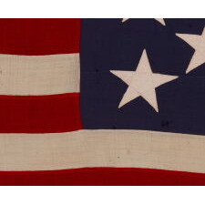 13 STAR ANTIQUE AMERICAN FLAG WITH A 3-2-3-2-3 PATTERN OF ESPECIALLY LARGE STARS; A U.S. NAVY SMALL BOAT ENSIGN, SIGNED & DATED 1914, MADE AT THE BROOKLYN NAVY YARD IN NEW YORK CITY