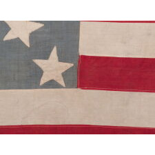 13 STAR ANTIQUE AMERICAN FLAG, A HOMEMADE EXAMPLE WITH AN INCREDIBLY RARE CONFIGURATION OF STARS THAT CONSISTS OF A BOX OF 9 WITH 4 OUTLIERS, SET AGAINST A LIGHT BLUE CANTON; LIKELY MADE IN CELEBRATION OF THE 1876 CENTENNIAL OF AMERICAN INDEPENDENCE; EXHIBITED AT THE MUSEUM OF THE AMERICAN REVOLUTION, JUNE-JULY 2019