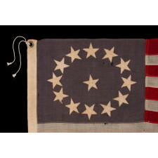 13 STARS ON A DUSTY BLUE CANTON, IN AN OVAL VERSION OF WHAT IS KNOWN AS THE 3RD MARYLAND PATTERN, MADE DURING THE LAST DECADE OF THE 19TH CENTURY, MARKED WITH THE SURNAME “NYE”