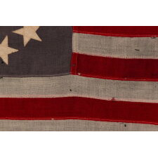 13 STARS ON A DUSTY BLUE CANTON, IN AN OVAL VERSION OF WHAT IS KNOWN AS THE 3RD MARYLAND PATTERN, MADE DURING THE LAST DECADE OF THE 19TH CENTURY, MARKED WITH THE SURNAME “NYE”
