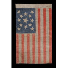 13 STARS IN A MEDALLION PATTERN ON AN ANTIQUE AMERICAN PARADE FLAG, MADE FOR THE 1876 CENTENNIAL OF AMERICAN INDEPENDENCE; A LARGE EXAMPLE AMONG ITS COUNTERPARTS OF THE PERIOD