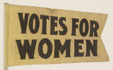 SMALL, TAPERED, FORKED TAIL SUFFRAGETTE PENNANT ON ITS ORIGINAL WOODEN STAFF WITH TEXT THAT READS "VOTES FOR WOMEN", CA 1910-1920
