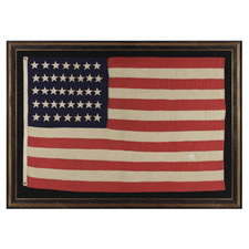 38 HAND-SEWN, SINGLE-APPLIQUED STARS ON AN ANTIQUE FLAG IN A SMALL SCALE FOR THE 19TH CENTURY, PROBABLY MADE BY THE ANNIN COMPANY IN NEW YORK CITY, 1876-1889, COLORADO STATEHOOD