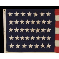 38 HAND-SEWN, SINGLE-APPLIQUED STARS ON AN ANTIQUE FLAG IN A SMALL SCALE FOR THE 19TH CENTURY, PROBABLY MADE BY THE ANNIN COMPANY IN NEW YORK CITY, 1876-1889, COLORADO STATEHOOD