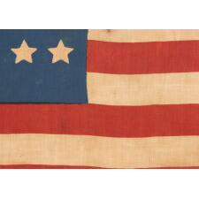 26 STAR ANTIQUE AMERICAN PARADE FLAG WITH 11 STRIPES AND IT’S CANTON RESTING ON THE “WAR STRIPE.” THE EARLIEST KNOWN STAR COUNT FOR PRINTED EXAMPLES, 1837-1846, MICHIGAN STATEHOOD