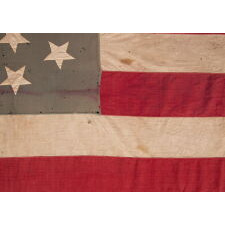 34 HAND-SEWN, UPSIDE-DOWN STARS ON A HOMEMADE, ANTIQUE AMERICAN FLAG WITH A VARIANT OF WHAT I HAVE CLASSIFIED AS A “GLOBAL” PATTERN, ON AN INTERESTING, SEAFOAM BLUE CANTON; REFLECTS KANSAS STATEHOOD, OPENING TWO YEARS OF THE CIVIL WAR, 1861-1863