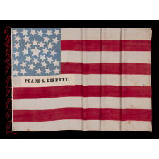 EXCEPTIONAL 34 STAR ANTIQUE AMERICAN CIVIL WAR FLAG WITH A CORNFLOWER BLUE CANTON, HOMEMADE & ENTIRELY HAND-SEWN ca 1861-63, WITH STRIPES THAT BEGIN & END ON WHITE, IN A COUNT OF 9 TO OMIT THE 4 SECEDED STATES FROM AMONG THE ORIGINAL 13 COLONIES, AND WITH APPLIED PANELS THAT READ: “PEACE & LIBERTY”; GIVEN TO DAVIS CAMRON OF “D” Co., 38th OH VOL. BY THE FAMILY OF ORRIN TAYLOR OF “D” & “F” Co.'s, 67th OH INFT'Y, MORTALLY WOUNDED AT APPOMATTOX ON THE VERY DAY OF LEE'S SURRENDER