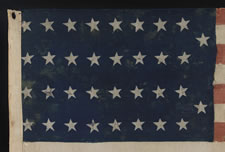 34 STARS IN 4 ROWS WITH 2 STARS OFFSET AT THE FLY END, LIKELY A UNION ARMY CAMP COLORS, OPENING TWO YEARS OF THE CIVIL WAR, 1861-1863, REFLECTS THE PERIOD WHEN KANSAS WAS THE MOST RECENT STATE TO JOIN THE UNION