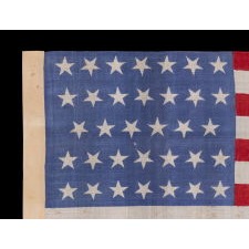 34 STARS WITH "DANCING" OR "TUMBLING" ORIENTATION, ON AN ANTIQUE AMERICAN FLAG WITH EXTRAORDINARY COLORS, PRINTED ON SILK, LIKELY PRODUCED FOR USE AS MILITARY CAMP COLORS, CIVIL WAR PERIOD, 1861-1863, REFLECTS THE ADDITION OF KANSAS TO THE UNION AS A FREE STATE