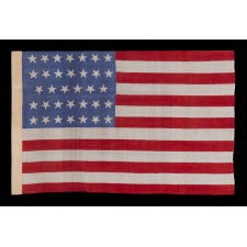 34 STARS WITH "DANCING" OR "TUMBLING" ORIENTATION, ON AN ANTIQUE AMERICAN FLAG WITH EXTRAORDINARY COLORS, PRINTED ON SILK, LIKELY PRODUCED FOR USE AS MILITARY CAMP COLORS, CIVIL WAR PERIOD, 1861-1863, REFLECTS THE ADDITION OF KANSAS TO THE UNION AS A FREE STATE