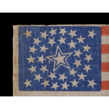 34 STARS IN A MEDALLION CONFIGURATION ON AN ANTIQUE AMERICAN PARADE FLAG WITH A LARGE, HALOED CENTER STAR; CIVIL WAR PERIOD, KANSAS STATEHOOD, 1861-1863