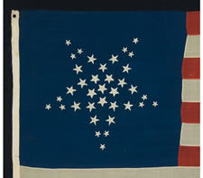 36 HAND-EMBROIDERED STARS IN TWO DIFFERENT SIZES, ARRANGED IN THE FORM OF A WHIMSICAL, INVERTED GREAT STAR PATTERN, AN EXTRAORDINARY HAND-SEWN EXAMPLE IN A RARE, SMALL SIZE, CIVIL WAR PERIOD, NEVADA STATEHOOD, 1864-67