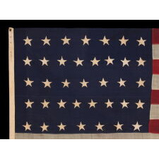 37 STAR ANTIQUE AMERICAN FLAG, ENTIRELY HAND-SEWN THROUGHOUT, WITH JUSTIFIED ROWS OF SINGLE-APPLIQUED STARS, MADE & SIGNED BY THE ANNIN COMPANY IN NEW YORK CITY, WITH SIGNIFICANT WEAR FROM EXTENDED USE; REFLECTS THE ERA WHEN NEBRASKA WAS THE MOST RECENT STATE TO JOIN THE UNION, 1867-1876