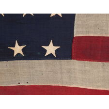 37 STAR ANTIQUE AMERICAN FLAG, ENTIRELY HAND-SEWN THROUGHOUT, WITH JUSTIFIED ROWS OF SINGLE-APPLIQUED STARS, MADE & SIGNED BY THE ANNIN COMPANY IN NEW YORK CITY, WITH SIGNIFICANT WEAR FROM EXTENDED USE; REFLECTS THE ERA WHEN NEBRASKA WAS THE MOST RECENT STATE TO JOIN THE UNION, 1867-1876