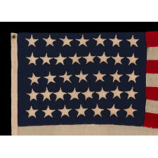 37 STAR ANTIQUE AMERICAN FLAG, MADE & SIGNED BY THE ANNIN COMPANY IN NEW YORK CITY, ENTIRELY HAND-SEWN AND WITH SINGLE-APPLIQUÉD STARS, IN A SMALL AND VERY DESIRABLE SCALE AMONG THOSE WITH PIECED-AND-SEWN CONSTRUCTION; REFLECTS THE ERA WHEN NEBRASKA WAS THE MOST RECENT STATE TO JOIN THE UNION, 1867-1876