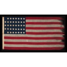 38 HAND-SEWN STARS IN A "NOTCHED" PATTERN, ON AN ANTIQUE AMERICAN FLAG WITH BEAUTIFUL WEAR FROM HAVING BEEN EXTENSIVELY FLOWN, MADE AT THE TIME WHEN COLORADO WAS THE MOST RECENT STATE TO JOIN THE UNION, 1876-1889