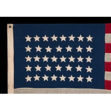 38 HAND-SEWN STARS IN AN UNUSUALLY CONFINED PATTERN OF JUSTIFIED ROWS, ON AN ANTIQUE FLAG IN AN ESPECIALLY SMALL SCALE FOR THE PERIOD, 1876-1889, COLORADO STATEHOOD