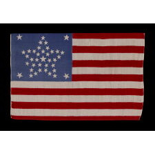 38 STAR AMERICAN PARADE FLAG WITH A RARE AND BEAUTIFUL VARIATION OF THE “GREAT STAR” OR “GREAT FLOWER” PATTERN, 4 LARGE CORNER STARS, & AN ODD OUTLIER, 1876-1889, COLORADO STATEHOOD, EXTRAORDINARILY RARE