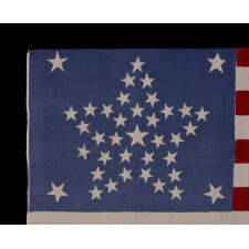 38 STAR AMERICAN PARADE FLAG WITH A RARE AND BEAUTIFUL VARIATION OF THE “GREAT STAR” OR “GREAT FLOWER” PATTERN, 4 LARGE CORNER STARS, & AN ODD OUTLIER, 1876-1889, COLORADO STATEHOOD, EXTRAORDINARILY RARE