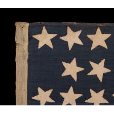 38 STAR ANTIQUE AMERICAN FLAG IN A TINY SCALE AMONG THOSE WITH PIECED-AND-SEWN CONSTRUCTION, WITH A BEAUTIFUL & UNUSUAL SHADE OF BLUE AND WITH A NOTCHED CONFIGURATION OF STARS THAT LEAVES ROOM FOR WESTERN TERRITORIES THAT HAD YET TO BE ADDED; REFLECTS THE PERIOD WHEN COLORADO WAS THE MOST RECENT STATE TO JOIN THE UNION, 1876-1889