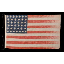 38 STAR ANTIQUE AMERICAN PARADE FLAG IN AN UNUSUALLY LARGE SCALE, WITH ENDEARING WAR FROM OBVIOUS LONG-TERM USE, AND WITH DANCING ROWS IN AN HOURGLASS FORMATION; COLORADO STATEHOOD, 1876-1889