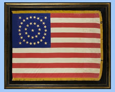 38 STAR FLAG WITH GILT-PAINTED STARS IN A MEDALLION CONFIGURATION, AN INDIAN WARS ERA BATTLE FLAG, 1876-1889, COLORADO STATEHOOD, HAND-SEWN SILK WITH GOLD FRINGE
