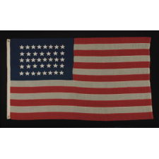 38 STAR FLAG WITH HAND-SEWN STARS, IN AN UNUSUALLY CONFINED PATTERN OF JUSTIFIED ROWS, ON AN ANTIQUE AMERICAN FLAG IN A SMALL SCALE FOR THE PERIOD, 1876-1889, COLORADO STATEHOOD