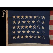 38 STAR FLAG WITH HAND-SEWN STARS IN A CONFINED PATTERN OF JUSTIFIED ROWS, ENDEARING WEAR, AND WONDERFUL PRESENTATION, 1876-1889, COLORADO STATEHOOD