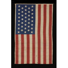 38 STARS IN A LINEAL ARRANGEMENT THAT IS COMPRISED OF JUST 5 ROWS OF CANTED STARS, UNUSUAL FOR A PARADE FLAG IN THIS STAR COUNT, PROBABLY MADE FOR THE CENTENNIAL INTERNATIONAL EXHIBITION IN PHILADELPHIA IN 1876, THIS STAR COUNT REFLECTING COLORADO STATEHOOD