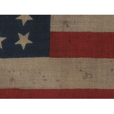 38 STARS IN A RARE CIRCLE-IN-A-SQUARE MEDALLION WITH A HUGE CENTER STAR, ON AN ANTIQUE AMERICAN FLAG MADE BY HORSTMANN BROS. IN PHILADELPHIA FOR THE 1876 CENTENNIAL INTERNATIONAL EXPOSITION, REFLECTS THE ADDITION OF COLORADO TO THE UNION