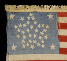 38 STARS IN A RARE GREAT STAR PATTERN, A SILK PARADE FLAG WITH GOLD SILK FRINGE, COLORADO STATEHOOD, 1876-1889