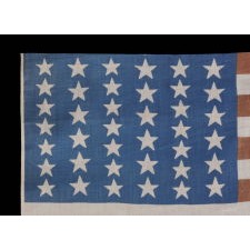 39 STARS IN TWO SIZES, ALTERNATING FROM ONE COLUMN TO THE NEXT, ON AN ANTIQUE AMERICAN PARADE FLAG WITH AN UNUSUALLY ELONGATED PROFILE, DATING TO THE 1876 CENTENNIAL, NEVER AN OFFICIAL STAR COUNT, REFLECTS THE ANTICIPATED ARRIVAL OF COLORADO AND THE DAKOTA TERRITORY
