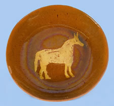 PENNSYLVANIA REDWARE PLATE BY MEDINGER, SLIP-DECORATED WITH RARE IMAGE OF A HORSE