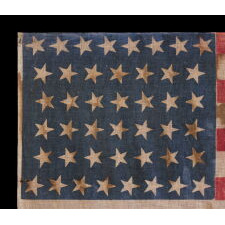 44 STAR ANTIQUE AMERICAN FLAG WITH AN HOURGLASS FORMATION OF STARS IN CANTED ROWS, AND AN EXTREMELY INTERESTING PRESENTATION FROM REPEATING SWATHS OF HEAVY OXIDATION, WYOMING STATEHOOD, 1890-1896