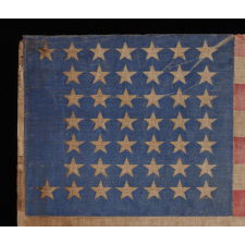 44 STAR ANTIQUE AMERICAN PARADE FLAG WITH A CORNFLOWER BLUE CANTON, ITS STARS ARRANGED IN A NOTCHED PATTERN, AND WITH A KEENLY ENDEARING PRESENTATION, 1890-1896, WYOMING STATEHOOD