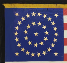 38 STAR FLAG WITH GILT-PAINTED STARS IN A MEDALLION CONFIGURATION, AN INDIAN WARS ERA BATTLE FLAG, 1876-1889, COLORADO STATEHOOD, HAND-SEWN SILK WITH GOLD FRINGE