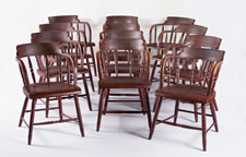 SET OF 12 BARREL-BACK WINDSOR CHAIRS, IN RED PAINT, WITH THE 3-LINK CHAIN (FRIENDSHIP, LOVE, AND TRUTH) OF THE ODD FELLOWS ON EACH CREST RAIL, CA 1850-70
