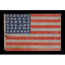 ANTIQUE 38 STAR FLAG WITH STRONG COLORATION AND ESPECIALLY FOLKY STARS, PRINTED ON A COTTON AND FLAX BLENDED FABRIC WITH A CRUDE WEAVE, COLORADO STATEHOOD, 1876-1889